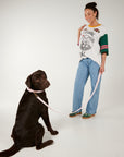 Woman standing next to a black dog on a white background