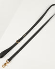 Black dog leash with gold hardware on a white background