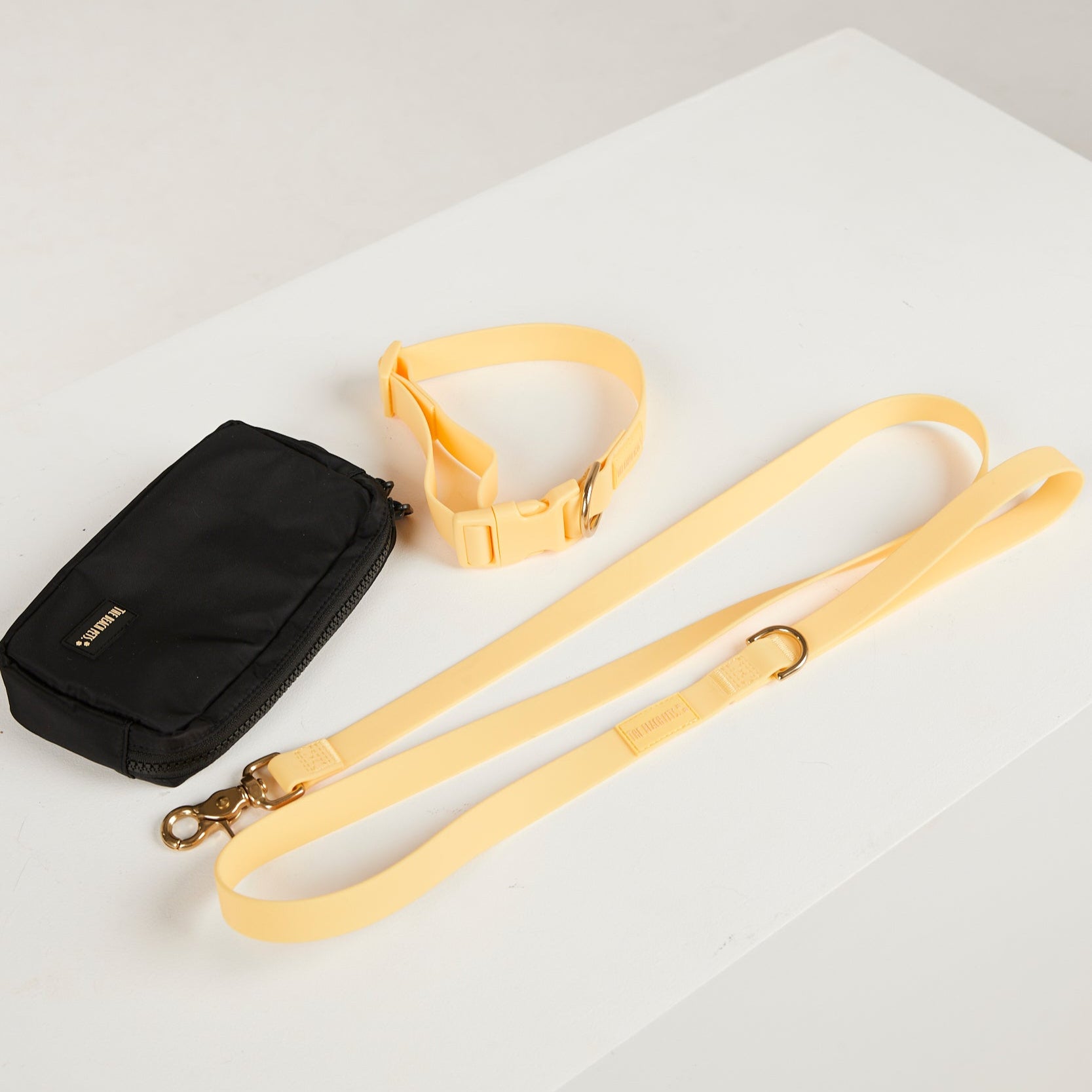 Black bag with a yellow strap on a white surface