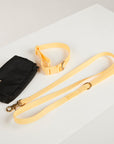 Black bag with a yellow strap on a white surface