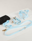 Dog harness and leash set with a black bag on a light gray background