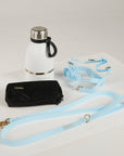 White thermos, black wallet, and light blue strap on a white background