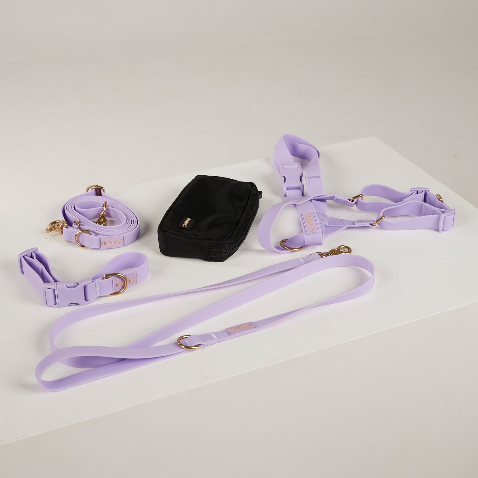 Lavender dog harness, leash, and collar set on a white surface