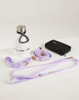 Dog collar, leash, and water bottle on a white surface