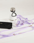 White water bottle with silver cap, black wallet, and purple dog leash on a white background
