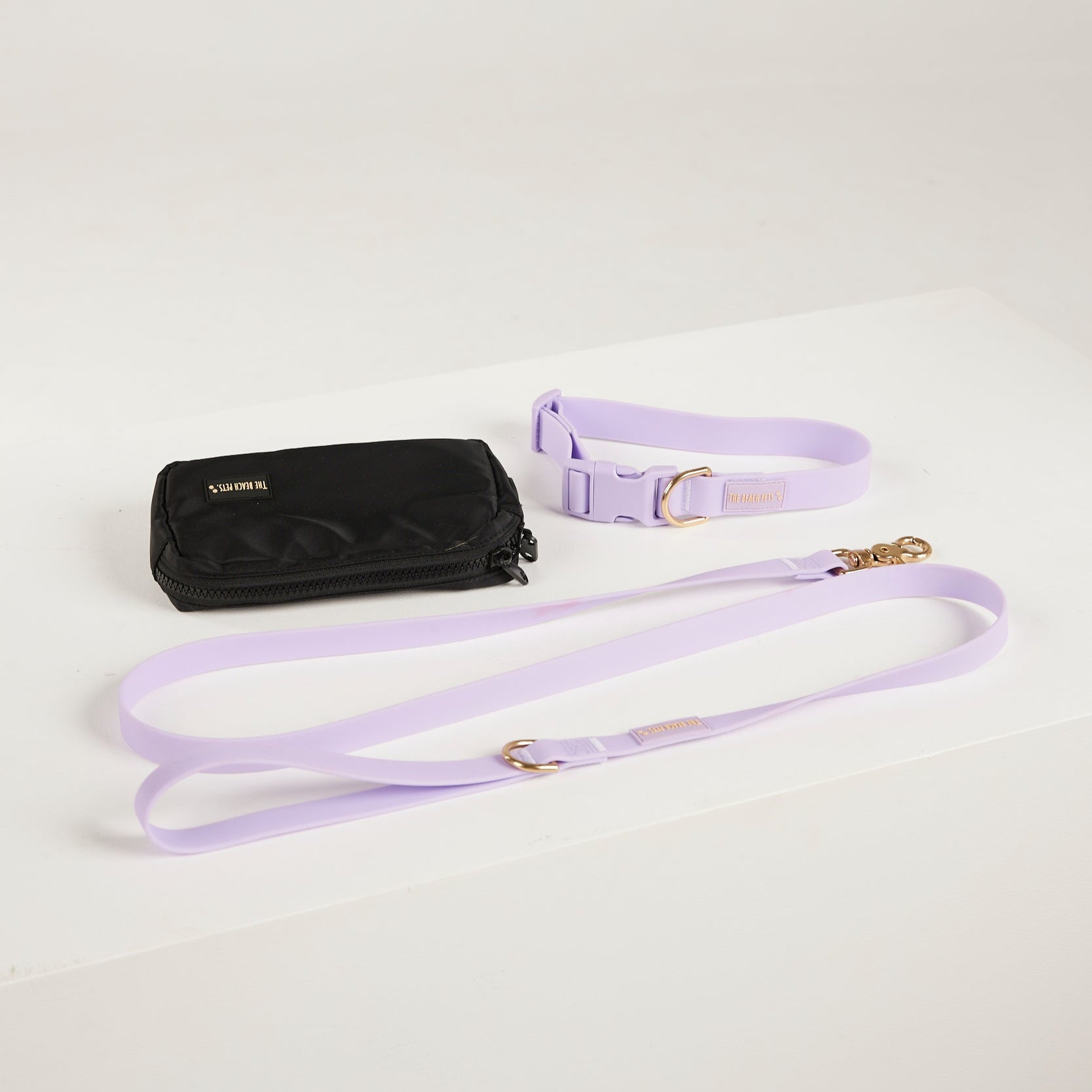 Black wallet with a purple strap on a light gray background