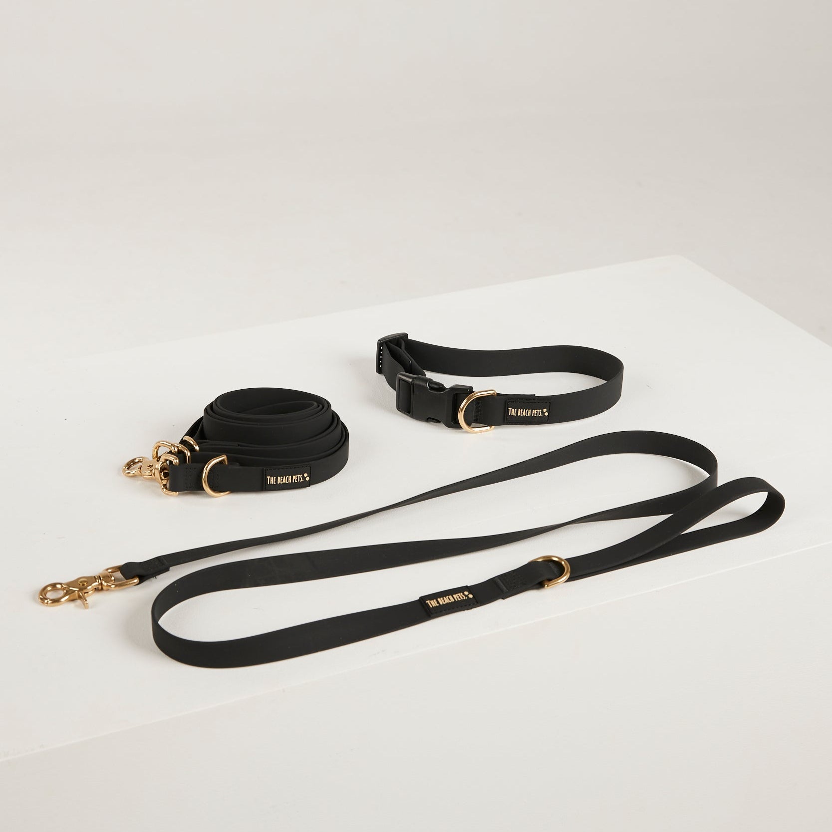 Black dog collar and leash set on a white background