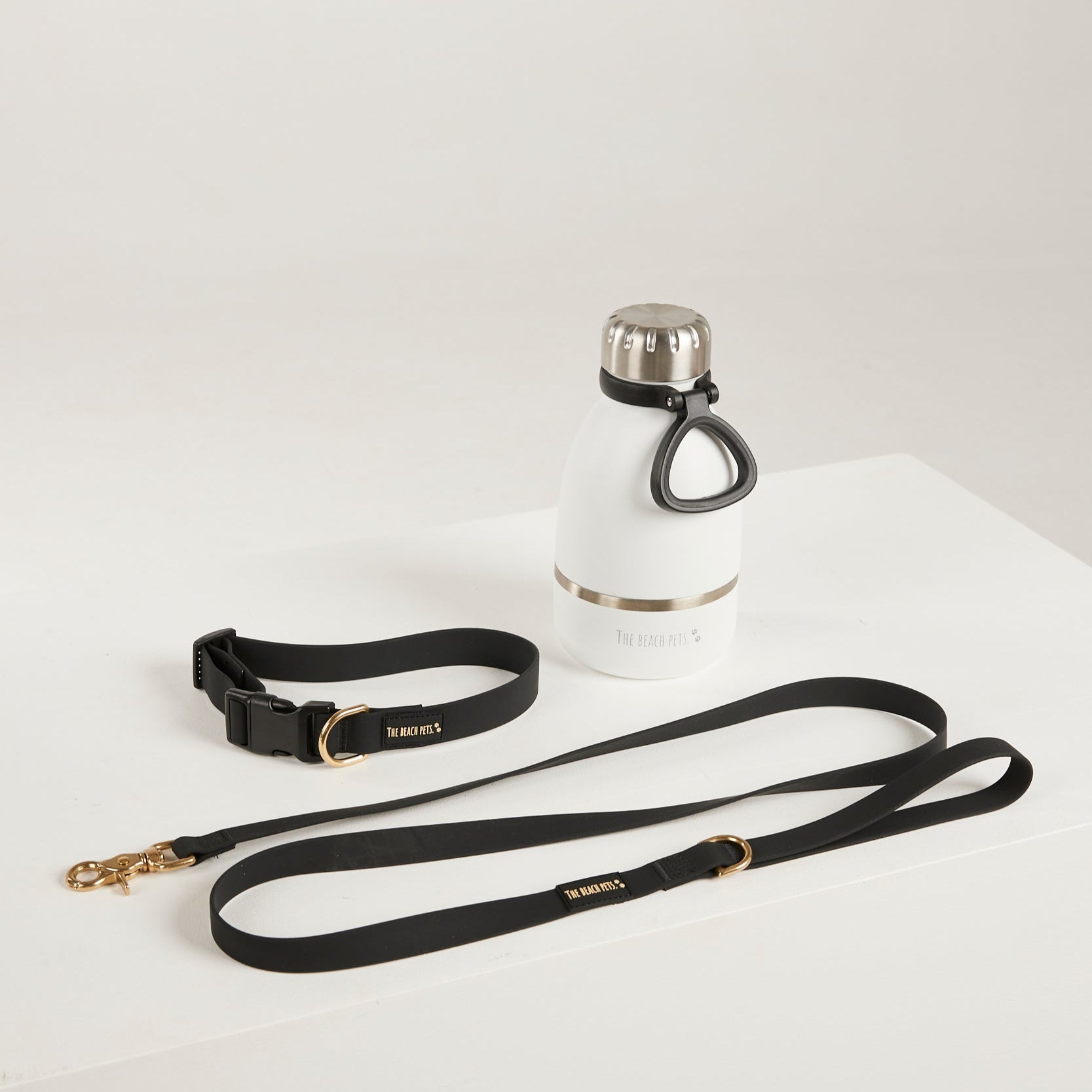 White water bottle with black leash on a light gray background