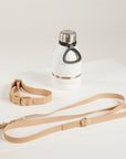 White water bottle with black cap and beige leash on a white background