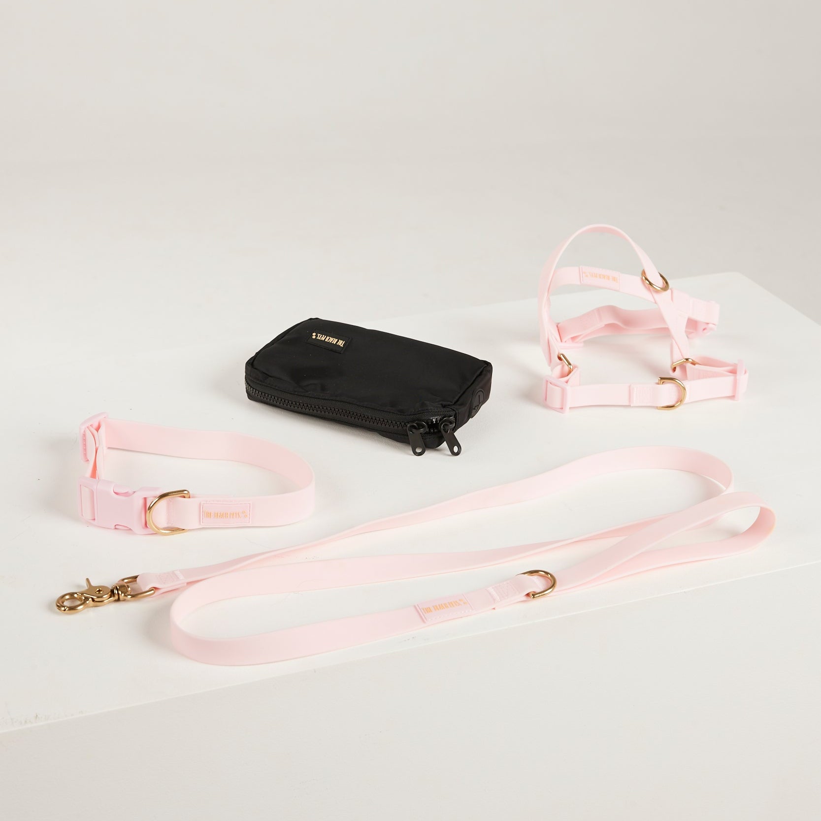 pink dog collar, dog harness, dog leash and poop bag