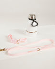 White water bottle with black cap and pink leash on a white background