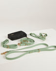 Green dog leash and black bag on a white background