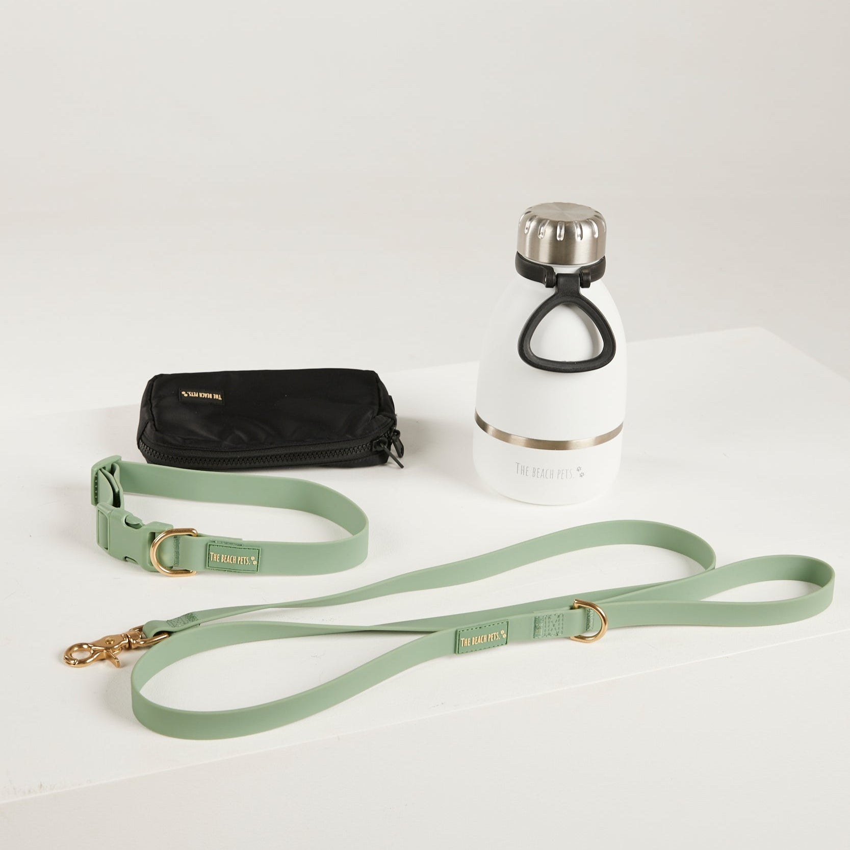 green dog lead, dog collar, bottle and poop bag