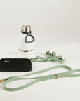 Black poop pouch. white water bottle with silver cap, and green dog leash