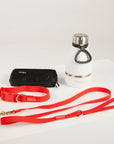 red dog lead, dog collar, bottle and poop bag