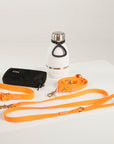 Dog leash, water bottle, and pouch on a white surface