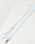 Light blue dog leash with gold clasp on a white background