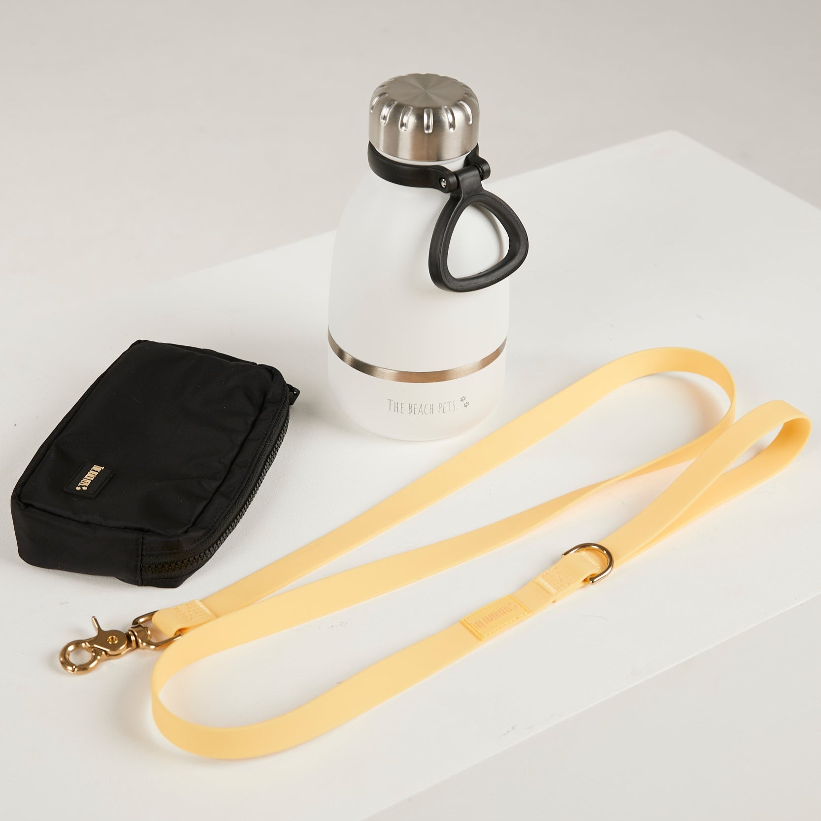 yellow dog leash, dog poop bag and dog waterbottle