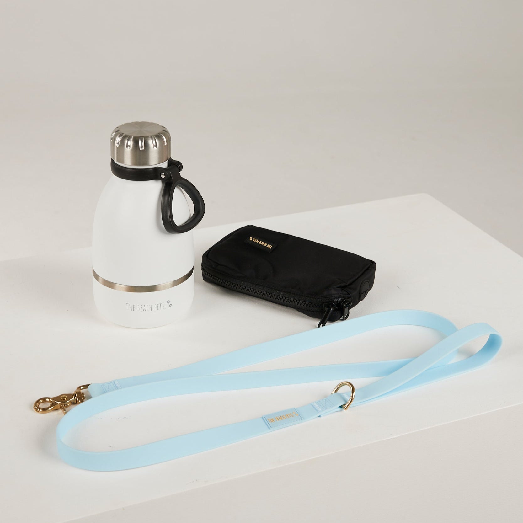 blue  dog leash, dog poop bag and dog waterbottle