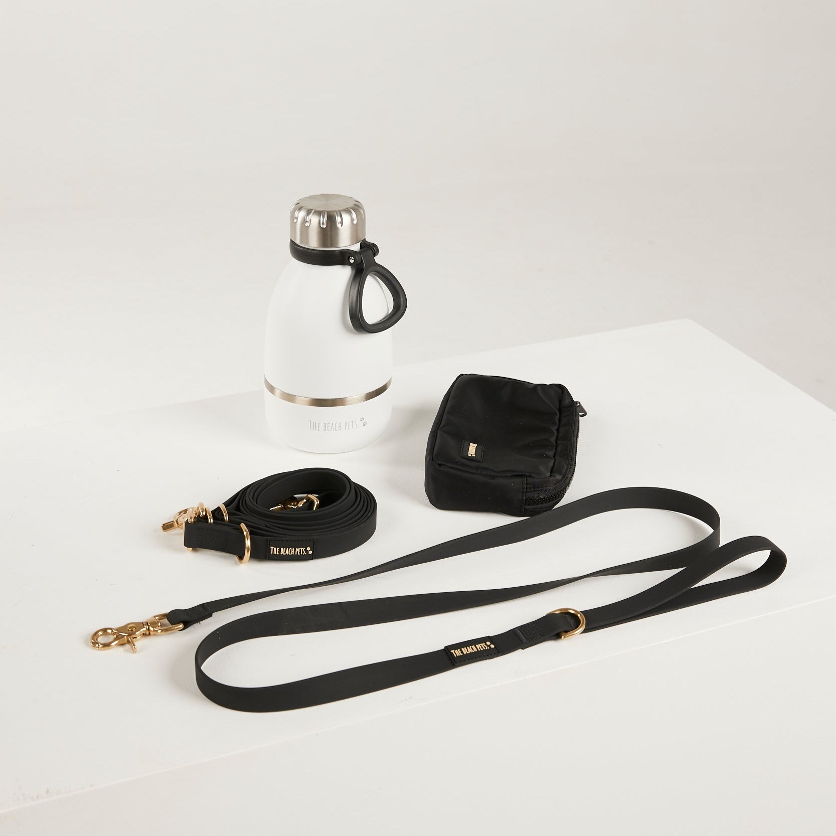 black dog lead, hands free lead, poop bag, bottle 