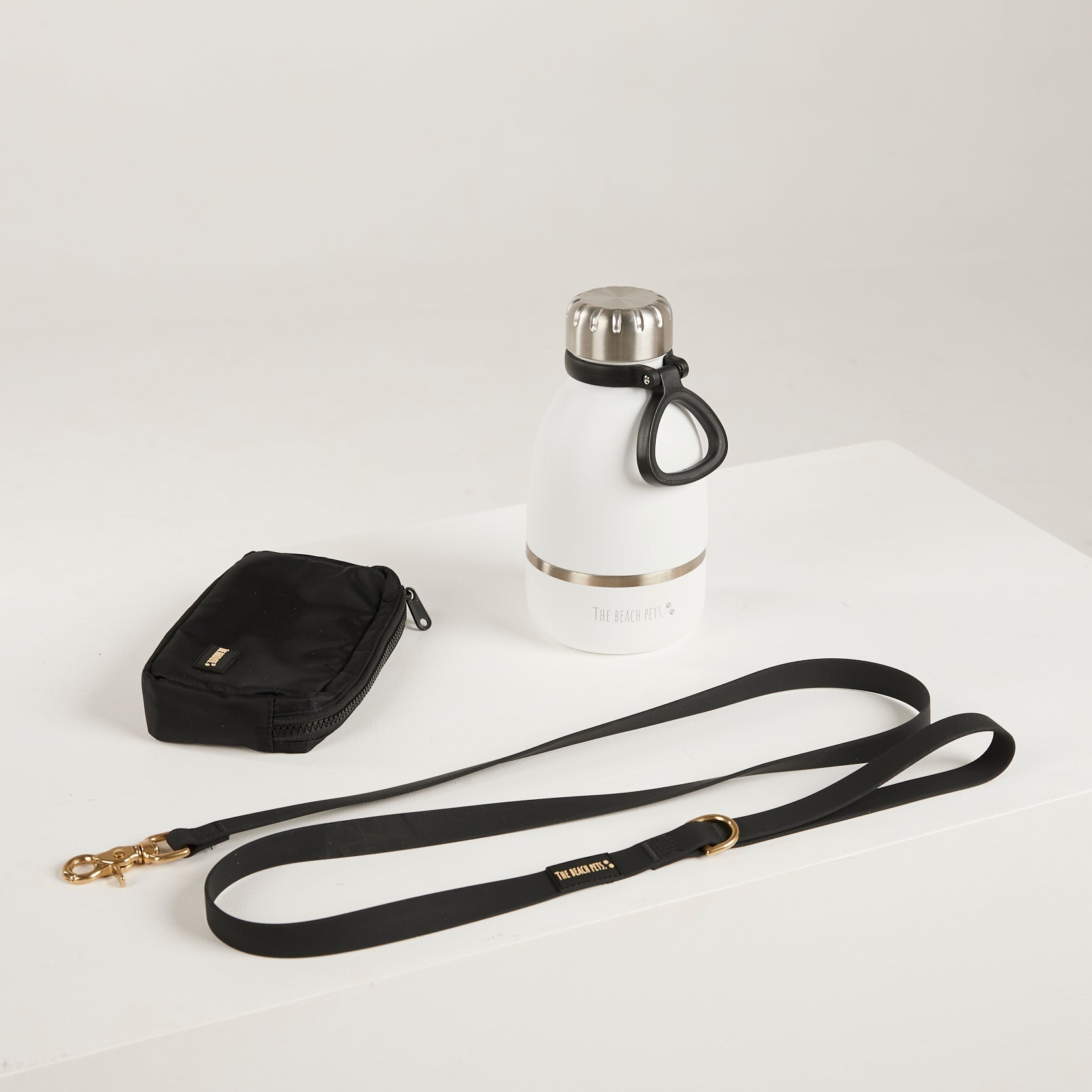 black  dog leash, dog poop bag and dog waterbottle