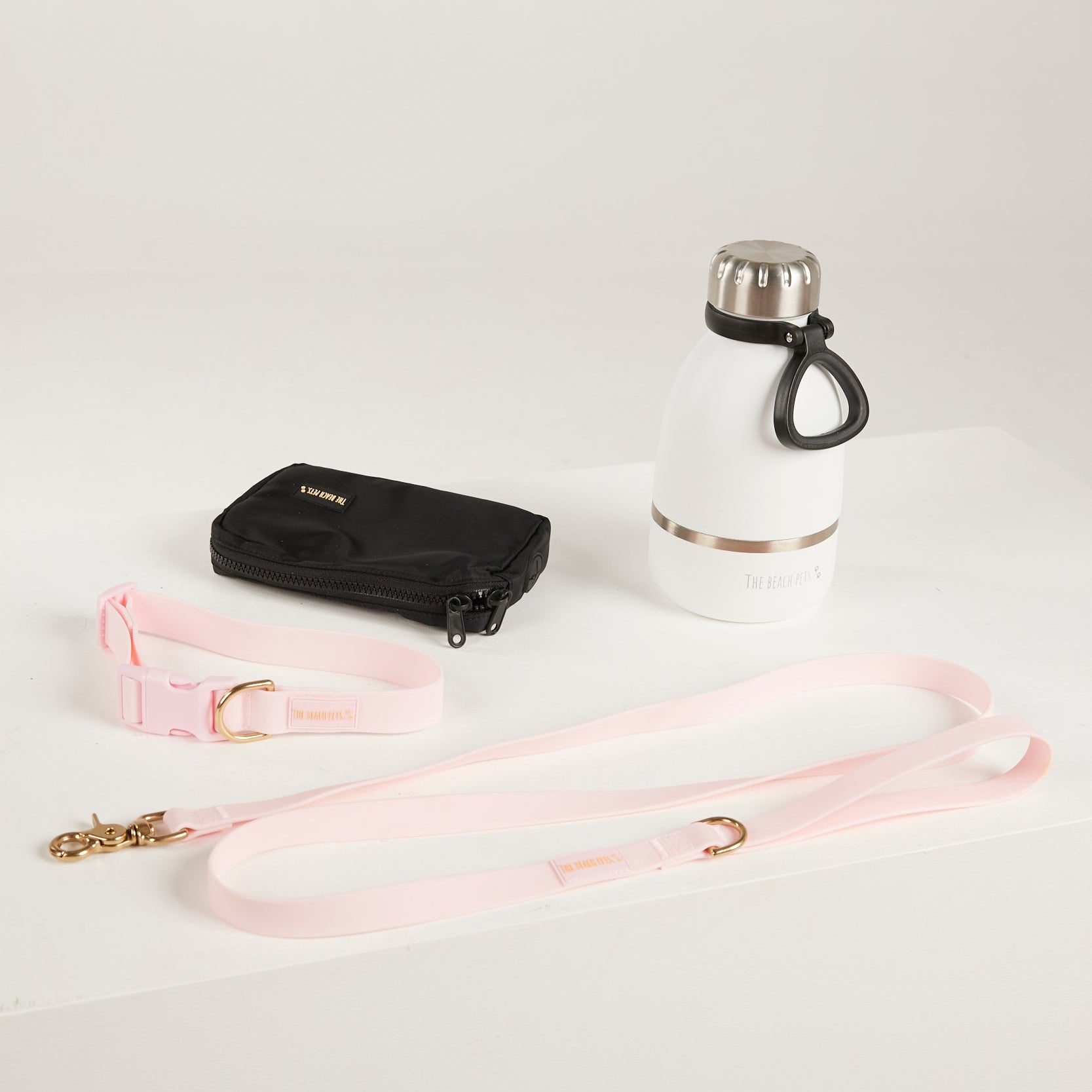 pink dog lead, dog collar, bottle and poop bag 