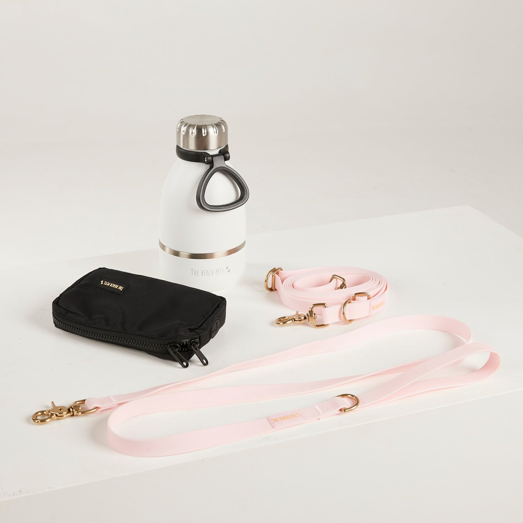pink dog lead, hands free lead, poop bag, bottle 