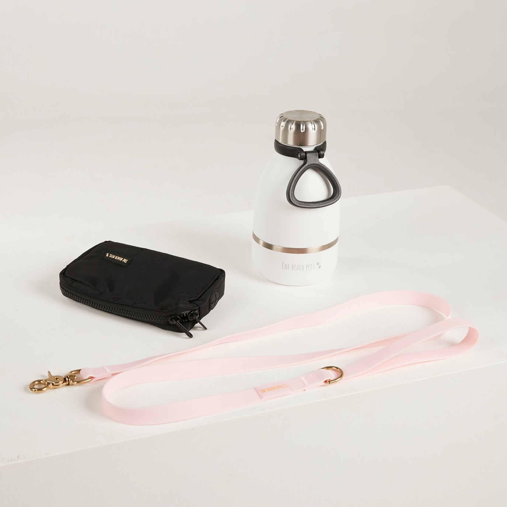 pink  dog leash, dog poop bag and dog waterbottle