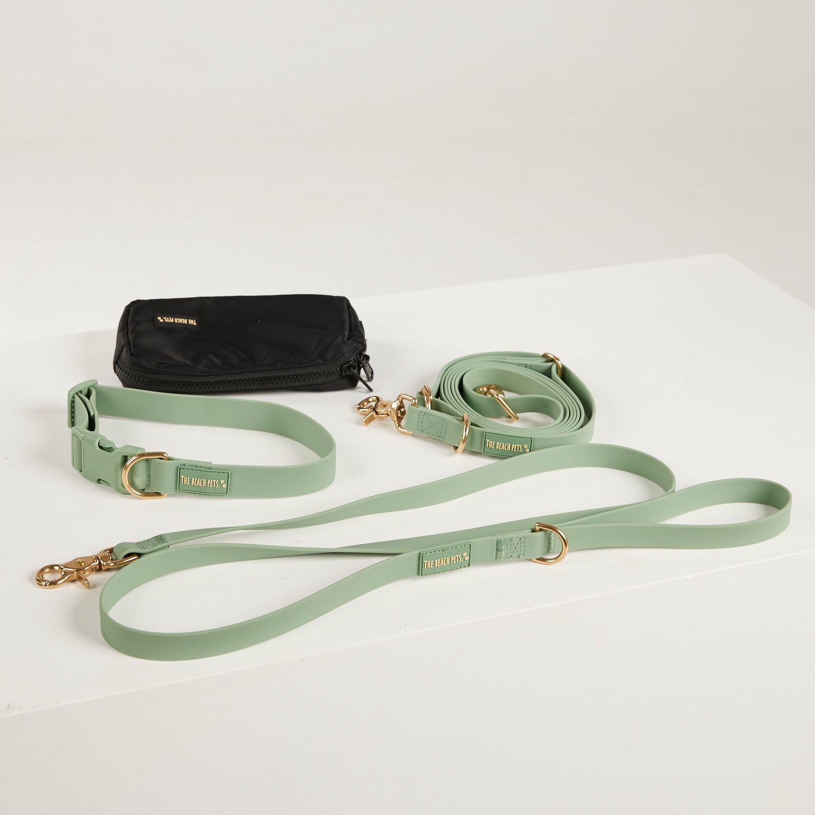 green  dog collar, dog lead and dog poop bag pouch