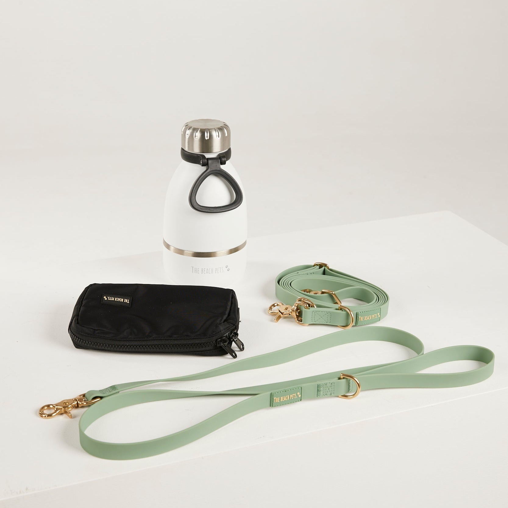 green dog lead, hands free lead, poop bag, bottle 