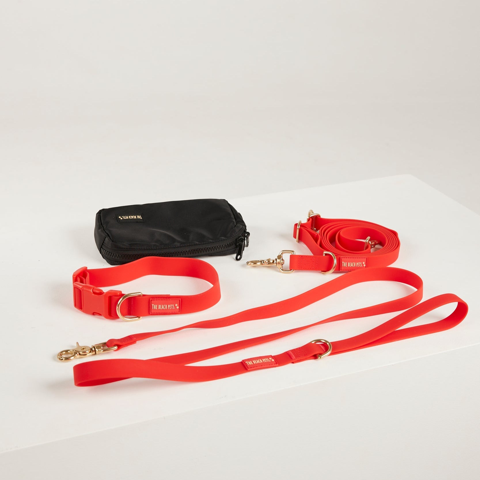 red  dog collar, dog lead and dog poop bag pouch