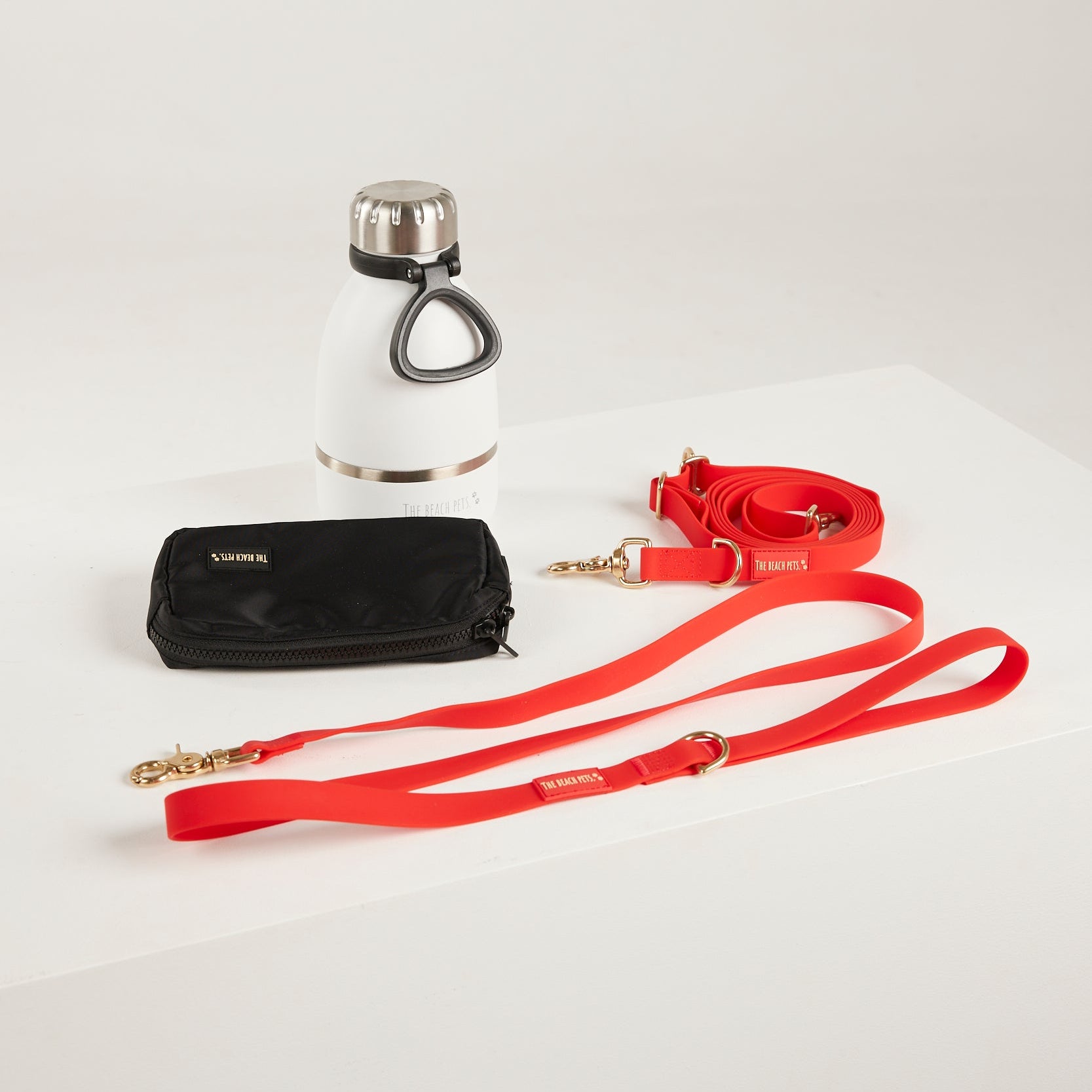 red dog lead, hands free lead, poop bag, bottle 