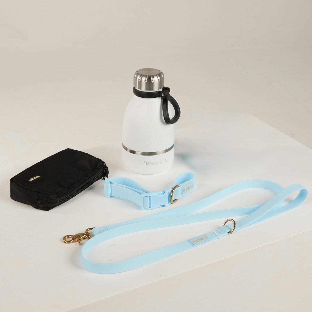 blue dog lead, dog collar, bottle and poop bag  